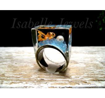 Anello realizzato in resina con inclusione di una perla di mare, pesce in miniatura e quarzi azzurri
